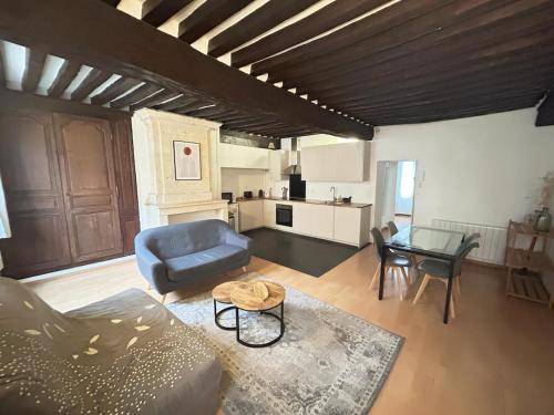 un salon avec un canapé bleu et une table dans l'établissement Appartement spacieux de charme en hyper-centre, à Caen