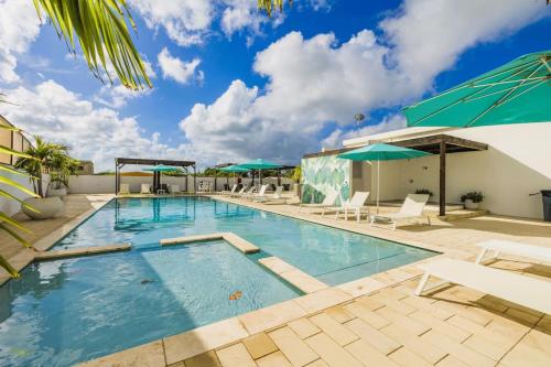 a large swimming pool with chairs and umbrellas at Bocobay LUX Villas Bubali in Palm-Eagle Beach