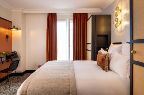 a hotel room with a bed and a desk at Grand Hôtel Chicago in Paris