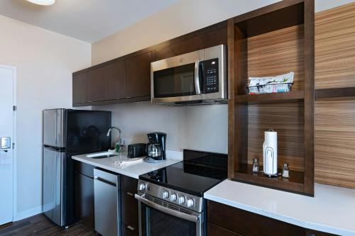 a small kitchen with a microwave and a refrigerator at TownePlace Suites El Paso North in Sunrise Acres