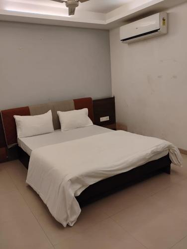 a bedroom with a large bed with white sheets and pillows at hotel nova haven in Ankleshwar