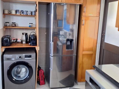 a kitchen with a refrigerator and a washing machine at Modern Beachfront Unit with Breathtaking Seaview's in Mtwalume