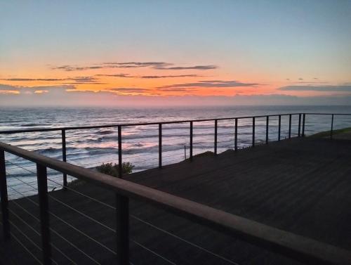 a view of the ocean at sunset from a balcony at Modern Beachfront Unit with Breathtaking Seaview's in Mtwalume