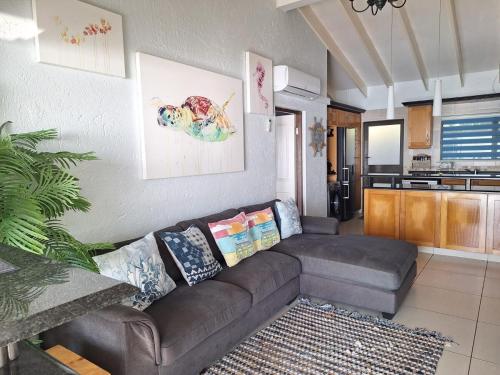 a living room with a couch and a kitchen at Modern Beachfront Unit with Breathtaking Seaview's in Mtwalume