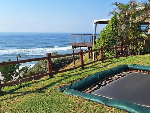 a trampoline on the grass next to the ocean at Modern Beachfront Unit with Breathtaking Seaview's in Mtwalume