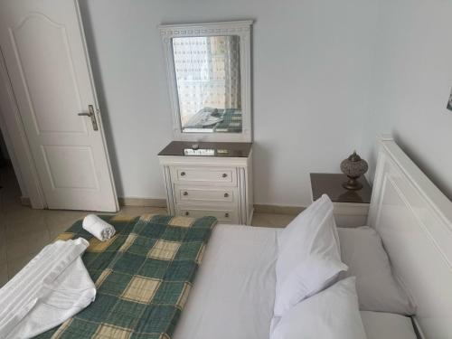 a bedroom with a white bed and a mirror at Delta Sharm Apartment 156 flat 102 in Sharm El Sheikh