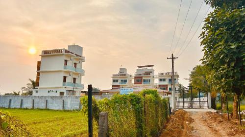 a group of buildings with a fence and a dirt road at Thavika Gold Mountain Wellness Resort in Tiruvannāmalai