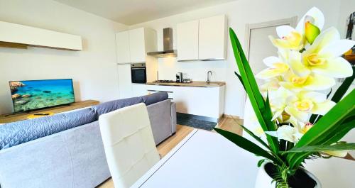 a living room with a couch and a kitchen at Vela House & Garden City Center in Olbia