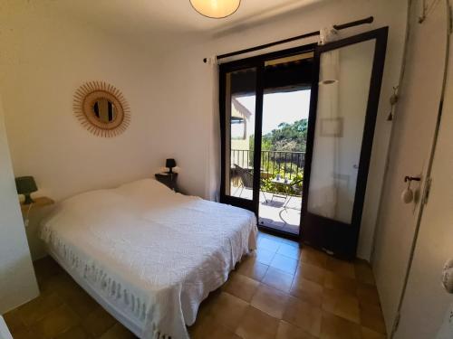 - une chambre avec un lit et une porte donnant sur un balcon dans l'établissement Sea view flat 5 minutes from the beach, à Théoule-sur-Mer