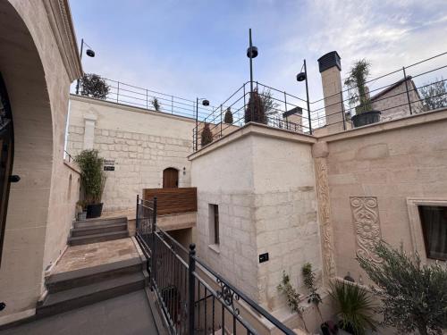 a building with stairs and a balcony with plants on it at Simurg Cave House in Urgup