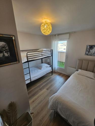 une chambre avec un lit superposé et une fenêtre dans l'établissement Stylish rooftop avec terrasse à 2pas de Disney Paris, à Montévrain