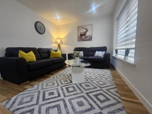 a living room with two couches and a table at LANGLEY APARTMENT free parking outside between 6 pm and 8 am Secure parking 2 min walk Ideal for TRADES AND TOURISTS WANTING GREAT LOCATION in Inverness