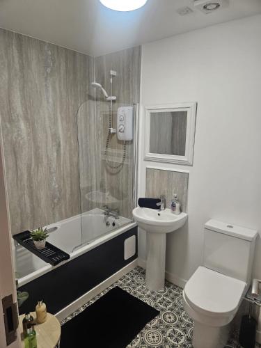 a bathroom with a tub and a toilet and a sink at Langley Apartment 2BR Sleeps 4 - great city centre location in Inverness
