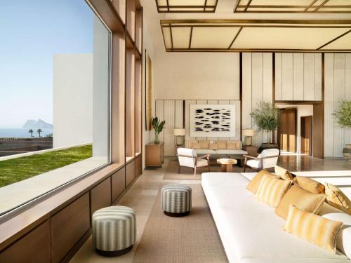a living room with a couch and a large window at Fairmont La Hacienda Costa del Sol in Alcaidesa