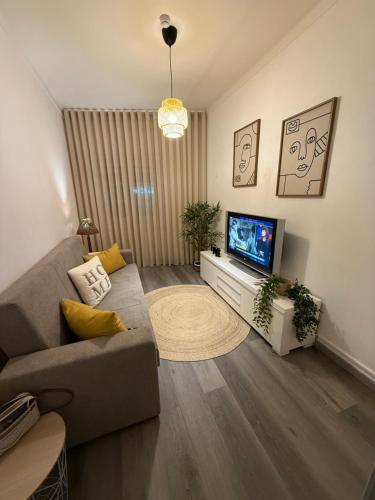a living room with a couch and a flat screen tv at Casa Santos in Sardoal