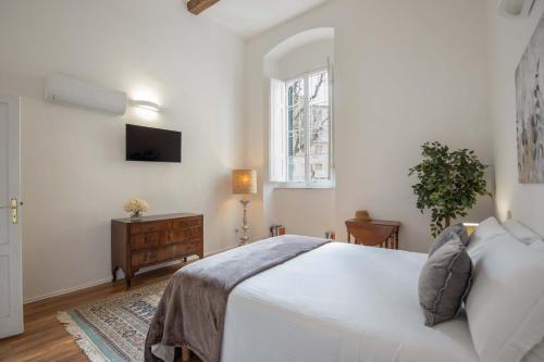 a white bedroom with a bed and a window at 900 - Guest House in Livorno