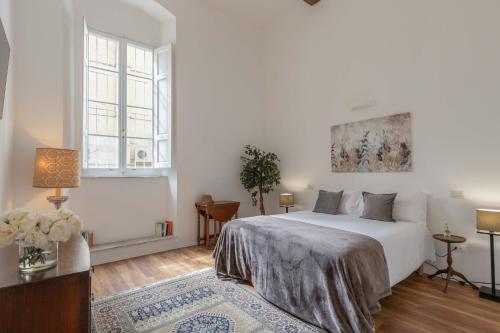 a white bedroom with a bed and a table at 900 - Guest House in Livorno