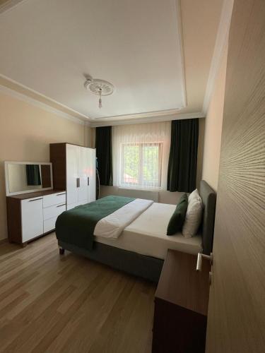 a bedroom with a large bed and a television at Salegan Pansiyon in Uzungöl