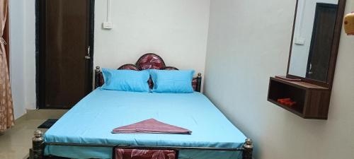 a bedroom with a blue bed with a mirror at CERRY BERRY Homestay in Guwahati