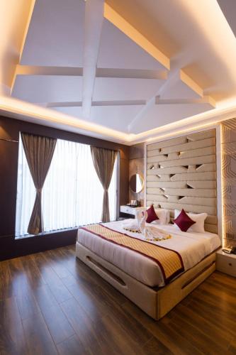 a bedroom with a large bed and a large window at Nachi Grand Residency in Devakottai