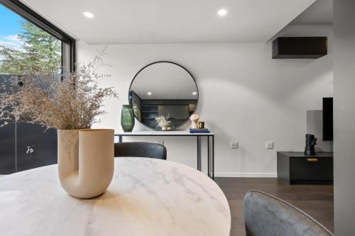 a dining room with a table and a mirror at Immaculate Braddon Studio with Accessible Bathroom in Turner