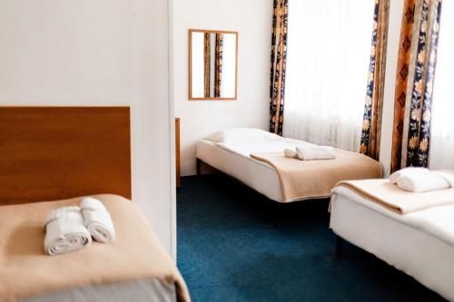 a hotel room with two beds and a mirror at Geovita Lądek Zdrój in Lądek-Zdrój