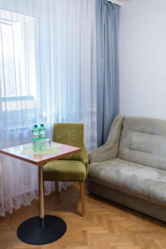 a living room with a couch and a table and a chair at Geovita Lądek Zdrój in Lądek-Zdrój