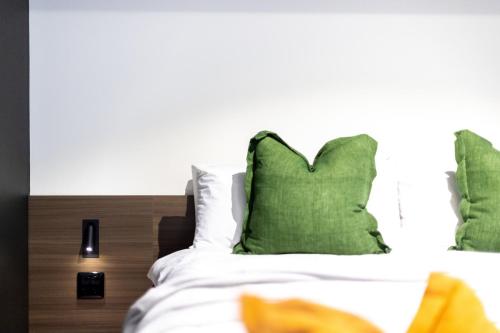 a bedroom with a bed with green pillows at Immaculate Braddon Studio with Accessible Bathroom in Turner