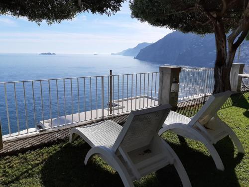 two white chairs sitting in front of the ocean at La Maliosa Positano in Positano