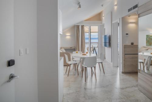 a kitchen and dining room with a table and chairs at Villa Primordia in Podgora