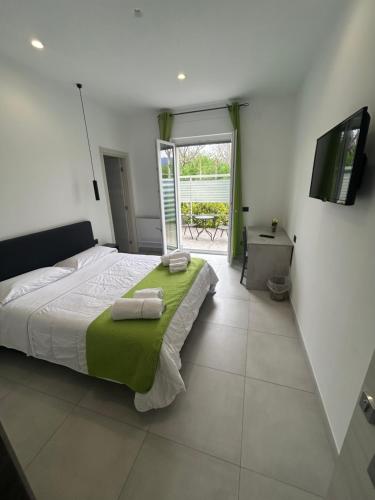 a bedroom with a large bed with a green blanket at La casa dei Coloni in Nola