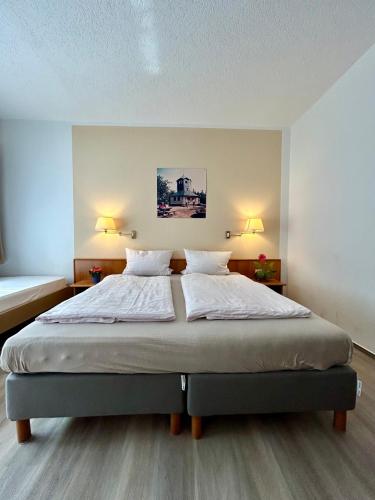 a bedroom with a large bed with two lamps at Pension zum Ritter in Katzhütte