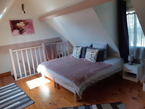 une chambre avec un lit avec des oreillers dessus dans l'établissement Le gîte LE MIEL du Périgord vert, à Dussac