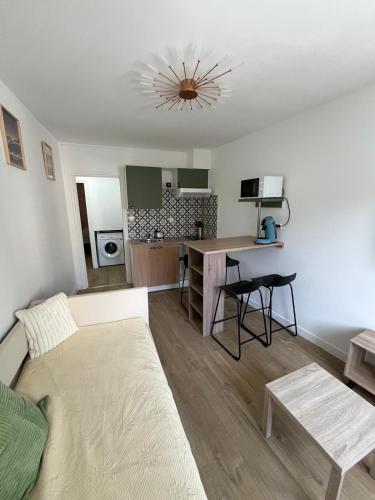 un salon avec un canapé et une cuisine dans l'établissement Les balcons du 115 - appartement standing 4 étoiles, à La Bourboule