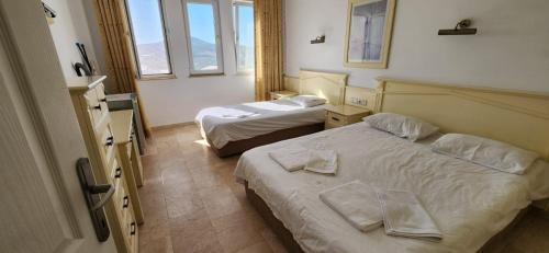 a hotel room with two beds and two windows at Goldctiy otel villa in Alanya