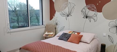 - une chambre avec un lit orné de fleurs sur le mur dans l'établissement Location circuit 24h, à Yvré-lʼÉvêque