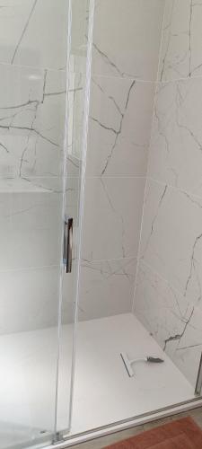 une cabine de douche avec une porte en verre et un rasoir dans l'établissement Location circuit 24h, à Yvré-lʼÉvêque