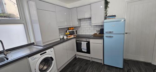 a kitchen with a refrigerator and a washing machine at Spacious 2 Bed Flat in Central Plymouth in Plymouth