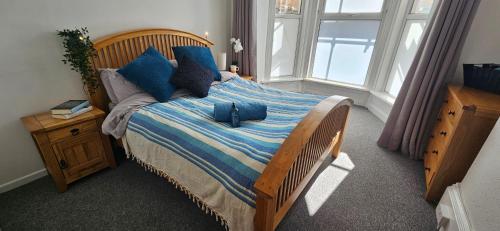 a bedroom with a large bed with blue pillows at Spacious 2 Bed Flat in Central Plymouth in Plymouth
