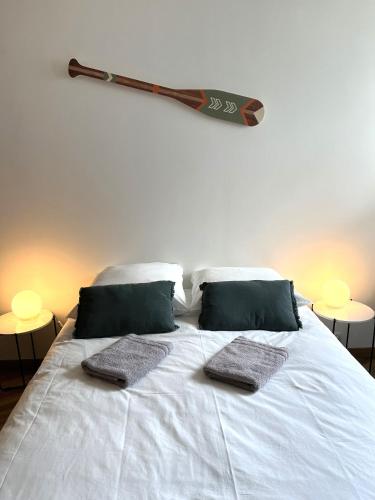 - un lit avec deux oreillers et une batte de baseball sur le mur dans l'établissement Vivez la Marina - Plage - Port de plaisance, au Havre