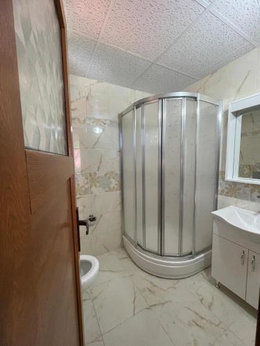 a bathroom with a shower with a toilet and a sink at Salegan Pansiyon in Uzungöl