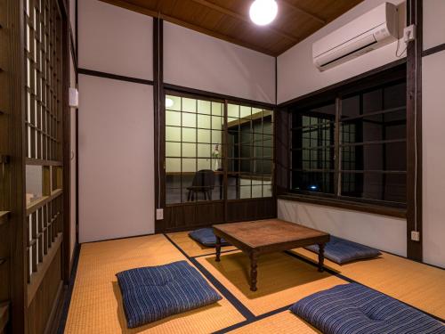 a room with a table and two large windows at NIPPONIA Sado 佐渡相川 金山町 in Sado
