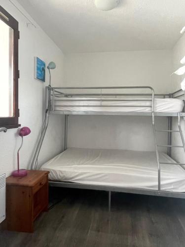 une chambre avec deux lits superposés dans une pièce dans l'établissement Gruissan Appartement Cosy Vue Port, à Gruissan