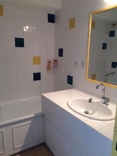 une salle de bain blanche avec un lavabo et un miroir dans l'établissement Gruissan Appartement Cosy Vue Port, à Gruissan