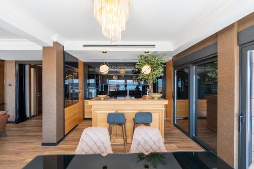 a kitchen with a bar with blue chairs at MonteLux Mansion in Tivat