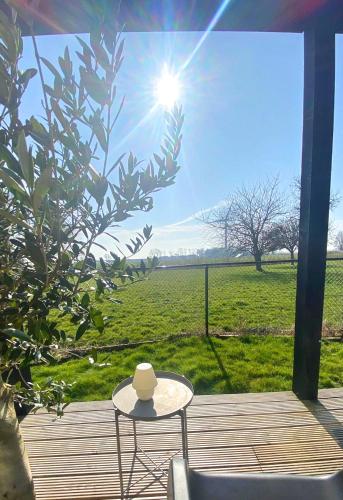 a table and chair on a deck with a view of a field at B&B NR6 in Herbaijum