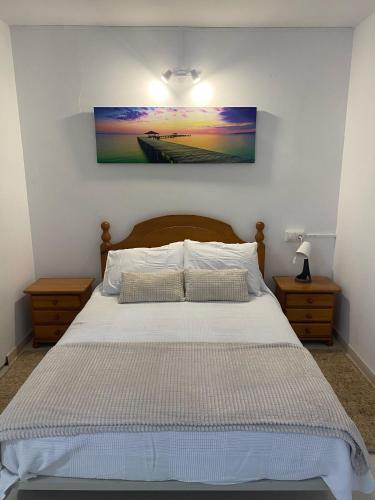 a bedroom with a bed with a picture on the wall at Casa Trasande in Couso