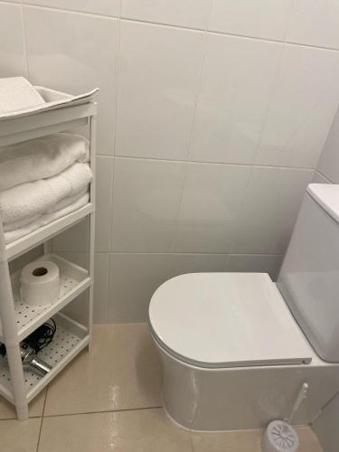 a bathroom with a white toilet and towels at Casa Trasande in Couso