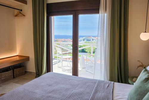 a bedroom with a bed and a sliding glass door at Barn Villa in Nikiti