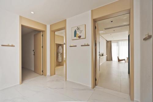 a hallway with white walls and white floors and doors at Dali Qiyu Half Hill Seaview Villa - Erhai Branch in Dali